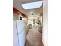 View of kitchen with white cabinets, tile floors, and a refrigerator at 10018 N 103 Ave, Sun City, AZ 85351