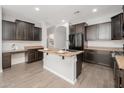 Spacious kitchen with dark wood cabinets, granite countertops, and an island at 18226 W Eva St, Waddell, AZ 85355