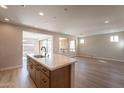 Open kitchen with island, stainless steel appliances, and hardwood floors at 375 E Bracciano Ave, Queen Creek, AZ 85140