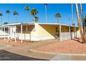 Side view of a yellow mobile home with covered carport and a small yard at 4065 E University Dr # 01, Mesa, AZ 85205