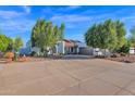 Front view of a single-story house with a large driveway and mature trees at 3401 N Dakota St, Chandler, AZ 85225