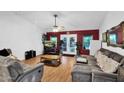 Living room with brown sofas, wood floors, and a large TV at 3401 N Dakota St, Chandler, AZ 85225