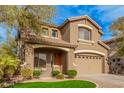 Two-story house with a landscaped yard, two-car garage, and inviting front porch at 322 E Caribbean Dr, Casa Grande, AZ 85122