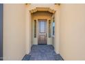 Front entry with a brown door and a paved walkway at 389 E Bracciano Ave, Queen Creek, AZ 85140