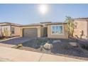 Tan colored house with a gray garage door and nicely landscaped yard at 389 E Bracciano Ave, Queen Creek, AZ 85140