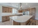 Modern kitchen with light wood cabinets, a large island, and stainless steel appliances at 389 E Bracciano Ave, Queen Creek, AZ 85140