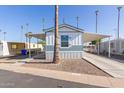 Single-wide manufactured home with covered carport and mature palm trees at 5201 W Camelback Rd # A187, Phoenix, AZ 85031