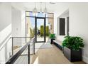 Bright and airy entryway with glass doors, light wood floors, and modern light fixtures at 6862 E Joshua Tree Ln, Paradise Valley, AZ 85253