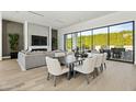 Open concept living area with hardwood floors, fireplace, and large windows at 6862 E Joshua Tree Ln, Paradise Valley, AZ 85253