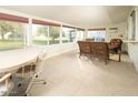 Bright sunroom with tiled flooring, wicker furniture, and large windows at 9542 W Shasta Dr, Sun City, AZ 85351