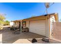 Home's side view, showcasing a garage and fenced yard at 411 N 111Th Pl, Mesa, AZ 85207