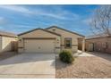 Tan house with a two-car garage and desert landscaping at 13157 E Chuparosa Ln, Florence, AZ 85132