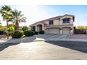 Two-story house with a three-car garage and palm trees in the front yard at 5322 N Oro Vista Ct, Litchfield Park, AZ 85340