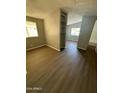 Open living room with wood-look floors and built-in shelving at 652 S Ellsworth Rd # 170, Mesa, AZ 85208