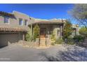 Front view of a Southwestern style home with a wooden door and stone accents at 3110 Arroyo Hondo --, Carefree, AZ 85377