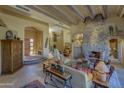 Spacious living room with a stone fireplace, high ceilings, and large windows at 3110 Arroyo Hondo --, Carefree, AZ 85377
