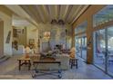 Living area showcasing a stone fireplace, wood beams, and access to backyard at 3110 Arroyo Hondo --, Carefree, AZ 85377