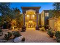 Grand home entrance with stone details and landscaping at 8595 E Bronco Trl, Scottsdale, AZ 85255