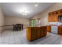 Kitchen boasts an island, granite countertops, and ample wood cabinets at 2606 N 89Th Dr, Phoenix, AZ 85037