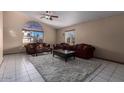 Spacious living room with tiled floors, large windows, and ample natural light at 2606 N 89Th Dr, Phoenix, AZ 85037