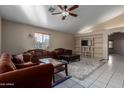 Bright living room with tiled floors, comfy furniture, and a ceiling fan at 2606 N 89Th Dr, Phoenix, AZ 85037