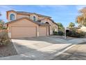 Two-story house with tan exterior, two-car garage, and landscaping at 2811 E Riviera Pl, Chandler, AZ 85249