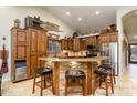 Rustic kitchen with ample cabinetry, an island, and stainless steel appliances at 5701 N 105Th Ln, Glendale, AZ 85307
