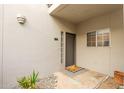 Condo entry with door, small porch, and potted plants at 7710 E Gainey Ranch Rd # 157, Scottsdale, AZ 85258