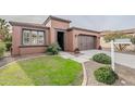 Single-story home with two-car garage and well-manicured lawn at 1587 E Luminous Ln, Queen Creek, AZ 85140