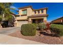 Two-story house with light brown exterior, two-car garage, and nicely landscaped yard at 174 E Baja Pl, Casa Grande, AZ 85122