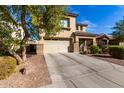Two-story house with beige exterior, two-car garage, and well-maintained landscaping at 174 E Baja Pl, Casa Grande, AZ 85122