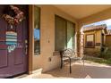 Front entrance with purple door, wreath, bench, and neighboring house visible at 174 E Baja Pl, Casa Grande, AZ 85122