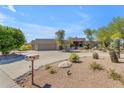 Single-story home with a two-car garage and well-manicured desert landscaping at 18612 E Adobe Cir, Rio Verde, AZ 85263