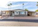 Front view of a manufactured home with a carport and mature palm trees at 3104 E Broadway Rd # 22, Mesa, AZ 85204