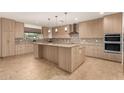 Modern kitchen with light wood cabinets, granite counters, and island at 6523 N 135Th Dr, Glendale, AZ 85307