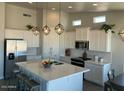 Modern kitchen featuring white cabinets, a large island, and stainless steel appliances at 13616 S 192Nd Ave, Buckeye, AZ 85326