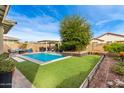 Spacious backyard with a refreshing pool, a pergola, and a beautifully landscaped lawn at 2949 N Acacia Way, Buckeye, AZ 85396