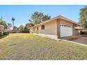 Side view of a brick home with a white garage door at 10205 W Royal Oak Rd, Sun City, AZ 85351