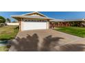 House exterior with a white garage door and a large driveway at 10728 W Cheryl Dr, Sun City, AZ 85351