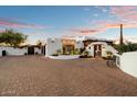 White stucco home with brick driveway and gated entrance at 7614 E Rocking Chair Rd, Carefree, AZ 85377