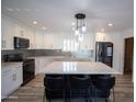 Modern kitchen with white cabinets, large island, and stainless steel appliances at 6746 W Acoma Dr, Peoria, AZ 85381