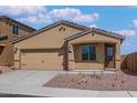 Tan exterior house with a two-car garage and desert landscaping at 10359 N 115Th Ave, Youngtown, AZ 85363