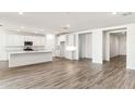 Open concept kitchen with white cabinets and an island at 15426 W Cottontail Ln, Surprise, AZ 85387