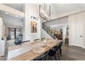 Spacious dining area with a long wooden table, modern chandelier, and views into the living room at 49 S Ocean Dr, Gilbert, AZ 85233