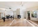 Open dining room with hardwood floors, fireplace, and access to patio at 7272 E Gainey Ranch Rd # 91, Scottsdale, AZ 85258