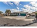 Front view of a single-story house with green garage door at 13023 W Skyview Dr, Sun City West, AZ 85375