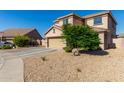 Two-story house with tan exterior, a two-car garage, and a landscaped front yard at 7921 S 26Th Dr, Phoenix, AZ 85041