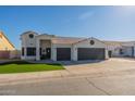 House exterior featuring a three-car garage and well-maintained lawn at 1113 N Cota Ln, Coolidge, AZ 85128