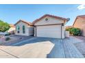 Tan stucco house with tile roof, two-car garage, and landscaped front yard at 1831 E Winged Foot Dr, Chandler, AZ 85249