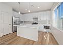 Modern kitchen featuring white cabinets, island, and light wood floors at 2200 N Iowa St, Chandler, AZ 85225